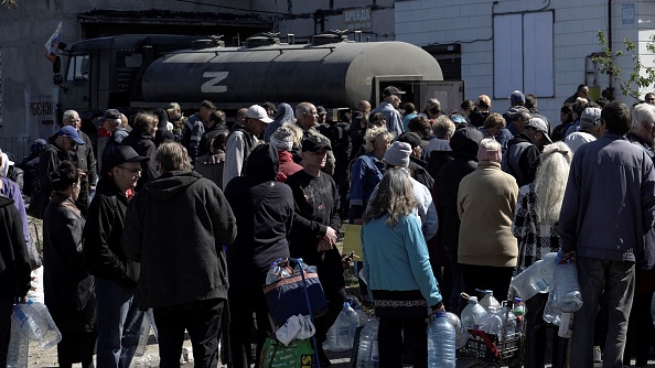 Les habitants font la queue pour aller chercher de l'eau dans la ville de Marioupol le 10 mai 2022. Photo par STRINGER/AFP via Getty Images.