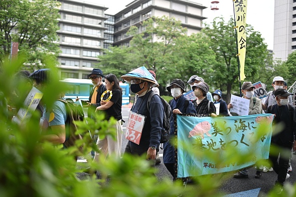 Des manifestants participent à une marche pour marquer le 50e anniversaire du départ américain d'Okinawa au Japon, à Tokyo le 15 mai 2022. Photo de Philip FONG / AFP via Getty Images.
