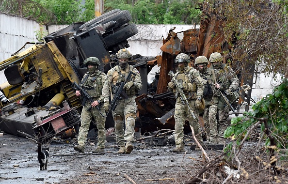 -Des militaires russes patrouillent dans la partie détruite de l'usine sidérurgique d'Ilyich dans la ville portuaire ukrainienne de Marioupol le 18 mai 2022. Photo par Olga MALTSEVA / AFP via Getty Images.