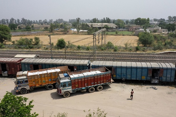 Des travailleurs chargent des sacs de blé de camions à un train de marchandises à la gare, en Inde dans l'État du Pendjab, le 19 mai 2022. Photo de SAJJAD HUSSAIN/AFP via Getty Images.