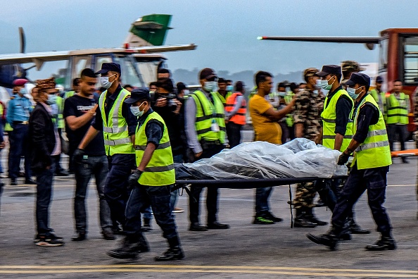 Le personnel de sécurité népalais transporte les corps des victimes de l'accident d'avion Twin Otter exploité par Tara Air qui s'est écrasé dans l'Himalaya avec 22 personnes à bord. 
(Photo  BIKASH KARKI/AFP via Getty Images)