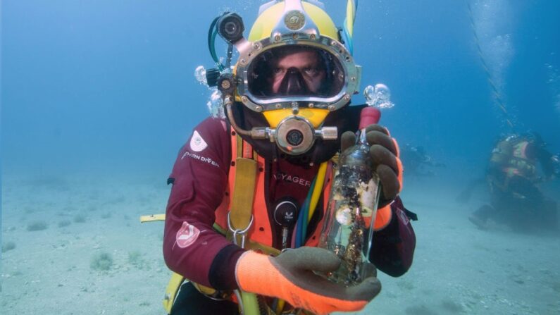 ILLUSTRATION : Un plongeur montre une bouteille après l'avoir sortie d'une cave à vin sous-marine.(BORIS HORVAT/AFP via Getty Images)