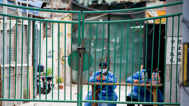 Des agents de sécurité surveillent une zone résidentielle confinée à Pékin, le 11 mai 2022. (NOEL CELIS/AFP via Getty Images)