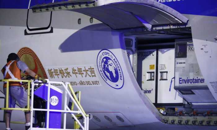 Un employé décharge des conteneurs d’un Airbus 330-200 d'Aerolineas Argentinas transportant 904 000 doses de vaccins chinois Sinopharm après son arrivée de la Chine à l'aéroport international d'Ezeiza, au sud-ouest de Buenos Aires, la capitale de l'Argentine, le 25 février 2021. (Marcos Brindicci/Getty Images)