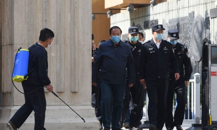 Des policiers et des fonctionnaires sortent d'un lycée à Pékin, le 27 avril 2020. (Greg Baker/AFP via Getty Images)
