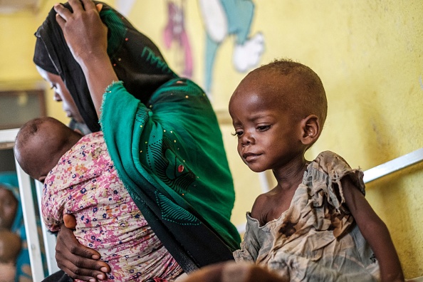Une enfant malnutrie est assise dans un lit à côté de sa mère à l'unité de nutrition du centre de santé de Kelafo, à 120 kilomètres de la ville de Gode, en Éthiopie, le 7 avril 2022. Photo par EDUARDO SOTERAS/AFP via Getty Images.