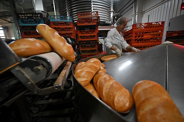 Une employée contrôle la qualité du pain cuit dans l'usine Tsar-Khlib du village, près de Kiev, le 25 mai 2022. Photo de Sergei SUPINSKY / AFP via Getty Images.