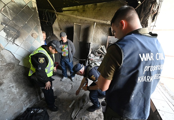 Des membres de l'équipe du procureur de Kharkiv examinent des preuves dans un appartement endommagé dans un immeuble résidentiel fortement endommagé au nord de Kharkiv, le 31 mai 2022. Photo Genya SAVILOV/AFP via Getty Images.