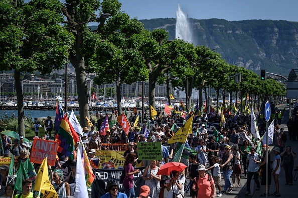 Des activistes marchent lors d'une manifestation contre l'Organisation mondiale du commerce à la veille de la conférence ministérielle de l'OMC à Genève, le 11 juin 2022. (Photo : FABRICE COFFRINI/AFP via Getty Images)