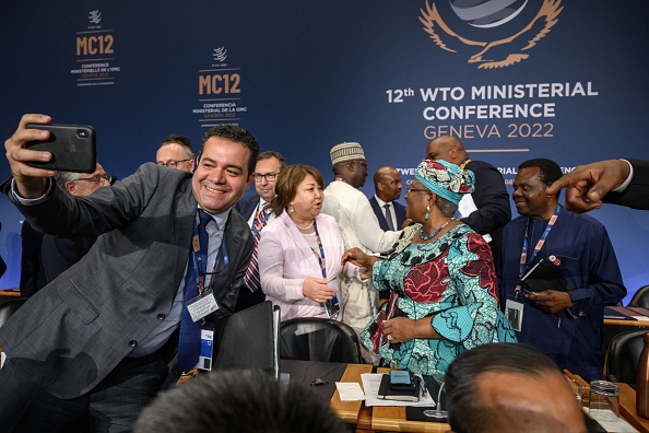 Les délégués et la directrice générale de l'Organisation mondiale du commerce, Ngozi Okonjo-Iweala, après une séance de clôture au siège de l'OMC à Genève, le 17 juin 2022. Photo de Fabrice COFFRINI / POOL / AFP via Getty Images.