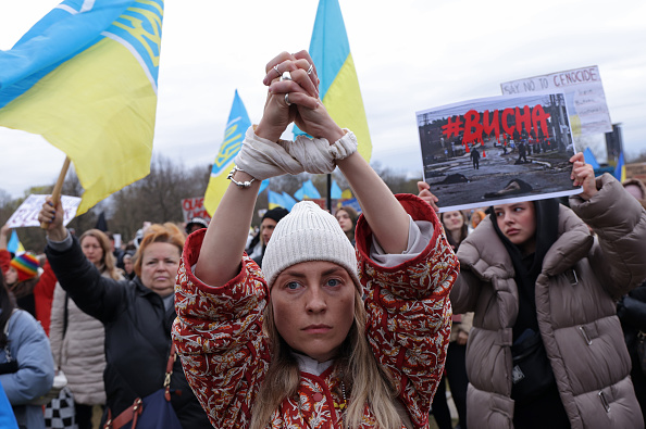 Une manifestante lève les mains symboliquement liées en référence aux civils ligotés, violés et assassinés de la ville ukrainienne de Bucha près de Kiev. Photo de Sean Gallup/Getty Images.