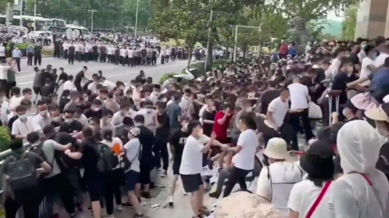 Dimanche vers midi, des groupes de personnes en civil – vêtues de blanc et de noir – ont violemment traîné et battu de nombreux déposants devant la Banque centrale chinoise de Zhenzhou (Capture d'écran)