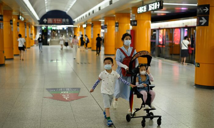 Femme avec deux enfants dans le métro à Pékin, le 5 juillet 2022. (WANG ZHAO/AFP via Getty Images)