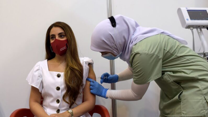 Une jeune femme se fait vacciner contre le Covid-19 au Centre international des expositions et des congrès de Bahreïn, à Manama, au Bahreïn, le 24 décembre 2020. (Mazen Mahdi/AFP via Getty Images) 