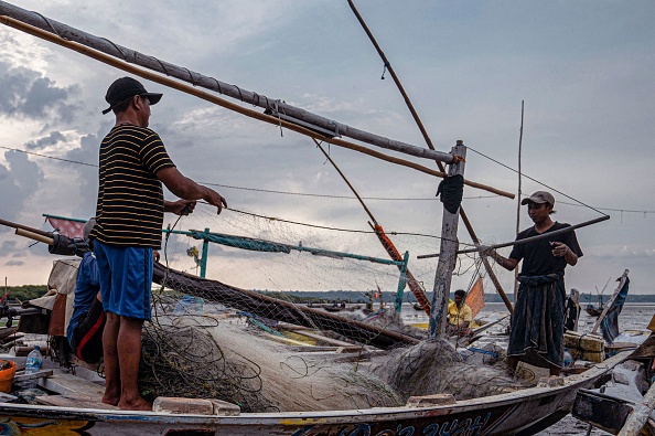 -Des pêcheurs se préparent avant d'aller pêcher de nuit à Surabaya le 16 avril 2022. Photo JUNI KRISWANTO/AFP via Getty Images.