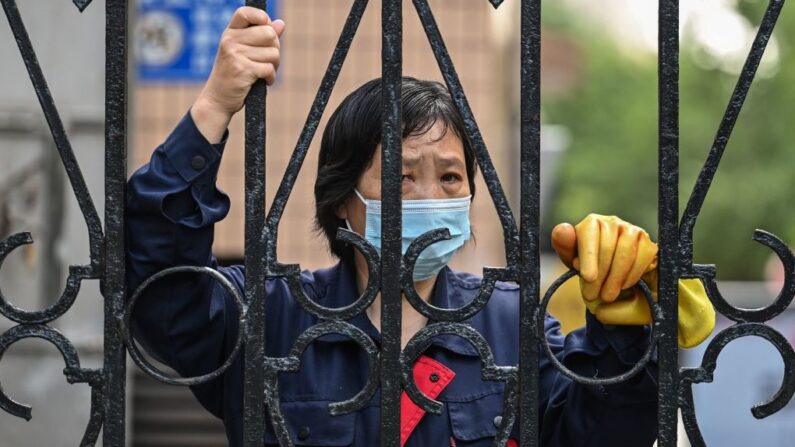 Habitante bloquée derrière une barrière durant le confinement de Shanghai dans le quartier de Jing'an, le 25 mai 2022. (HECTOR RETAMAL/AFP via Getty Images)