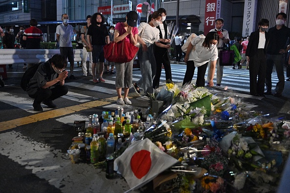 Les gens rendent hommage devant un mémorial de fortune, où l'ancien Premier ministre japonais Shinzo Abe a été abattu, à Nara le 8 juillet 2022. Photo PHILIP FONG/AFP via Getty Images.