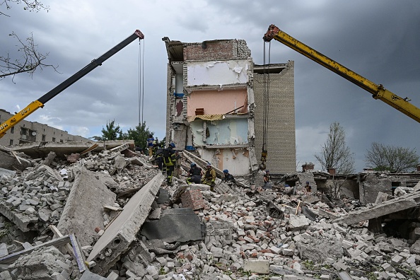 -Les sauveteurs cherchent des survivants sur un bâtiment partiellement détruit à la suite d'un tir de missile russe à Chasiv Yar, le 10 juillet 2022. Photo de MIGUEL MEDINA/AFP via Getty Images.