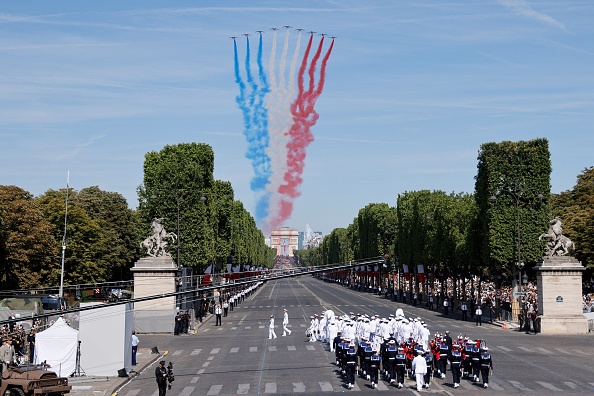 La Patrouille de France dégage de la fumée aux couleurs du drapeau français lors du défilé militaire du 14 juillet sur l'avenue des Champs-Élysées à Paris le 14 juillet 2022. Photo par Ludovic MARIN / AFP via Getty Images.