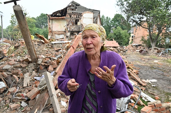 -Une résidente locale, Raisa Kuval, 82 ans, à côté d'un bâtiment partiellement détruit après un bombardement à l'est de Kharkiv, le 16 juillet 2022. Photo de SERGEY BOBOK / AFP via Getty Images.
