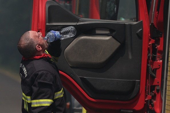 Un pompier boit de l'eau lors d'une opération pour tenter de maîtriser un feu de forêt près de Louchats en Gironde, dans le sud-ouest de la France, le 17 juillet 2022. (THIBAUD MORITZ/AFP via Getty Images)