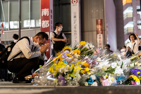 Un homme prie à l'extérieur de la gare où l'ancien Premier ministre japonais Shinzo Abe a été abattu plus tôt dans la journée le 8 juillet 2022 à Nara, au Japon. (Photo de Yuichi Yamazaki/Getty Images)