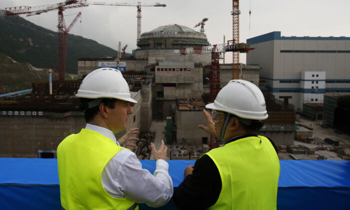Le chancelier de l'Échiquier britannique George Osborne (à g.) avec le directeur général de Taishan Nuclear Power Joint Venture Guo Liming devant un réacteur nucléaire en construction dans une centrale nucléaire à Taishan, dans la province du Guangdong, le 17 octobre 2013. (Bobby Yip/AFP/Getty Images)
