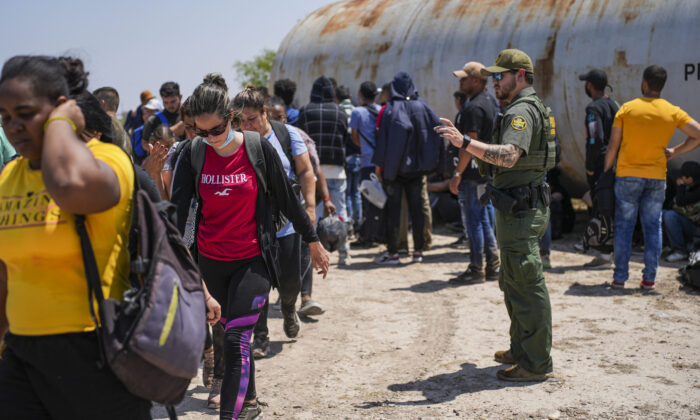 Agent de la patrouille frontalière encadrant un grand groupe d'immigrés clandestins près d'Eagle Pass, au Texas, le 20 mai 2022. (Charlotte Cuthbertson/Epoch Times)