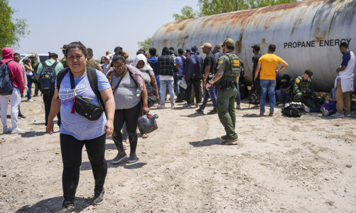 Agent de la patrouille frontalière en train d’encadrer un groupe important d’immigrés clandestins près d'Eagle Pass, au Texas, le 20 mai 2022. (Charlotte Cuthbertson/Epoch Times)