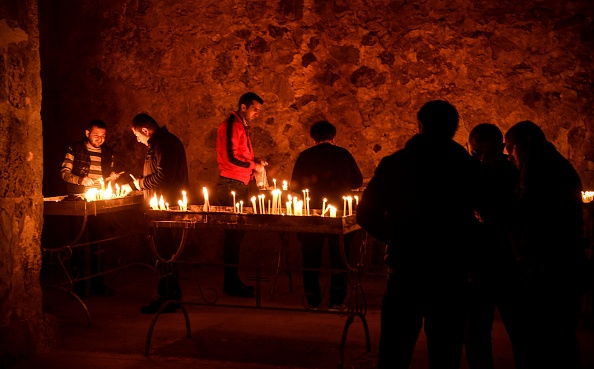 Des soldats arméniens allument des bougies alors qu'ils rendent un dernier hommage aux camarades tombés lors du conflit militaire entre l'Arménie et l'Azerbaïdjan au sujet de la région séparatiste du Haut-Karabakh, le monastère orthodoxe de Dadivank, à la périphérie de Kalbajar, le 14 novembre 2020. (Photo ALEXANDER NEMENOV/AFP via Getty Images)