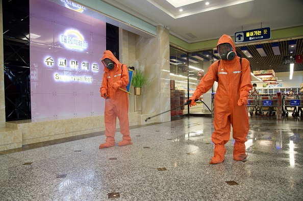 Les responsables de la santé pulvérisent du désinfectant dans le cadre des mesures préventives contre le Covid-19, dans un grand magasin à Pyongyang le 27 septembre 2021. Photo de KIM Won Jin / AFP via Getty Images.