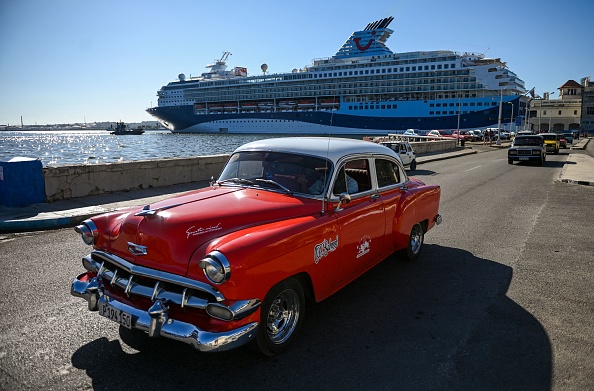Une vieille voiture américaine passe devant le bateau de croisière Marella Explorer 2 dans le port de La Havane, le 4 mars 2022. (Photo : YAMIL LAGE/AFP via Getty Images)