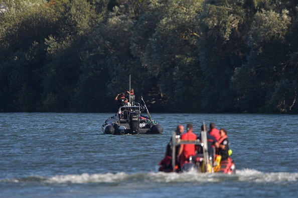 Des membres de l'ONG Sea Shepherd et des pompiers patrouillent dans des bateaux à la recherche d'un béluga, qui a été repéré alors qu'il remontait la Seine près d'une écluse à Courcelles-sur-Seine, le 5 août 2022. (Photo : JEAN-FRANCOIS MONIER/AFP via Getty Images)