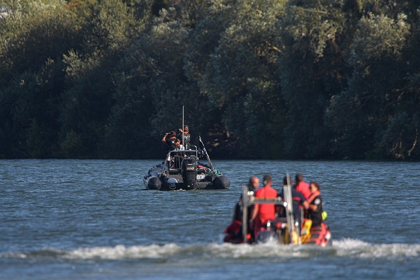 Des membres de l'ONG Sea Shepherd et des pompiers patrouillent dans des bateaux à la recherche d'un béluga, qui a été repéré alors qu'il remontait la Seine près d'une écluse à Courcelles-sur-Seine, le 5 août 2022. (Photo : JEAN-FRANCOIS MONIER/AFP via Getty Images)