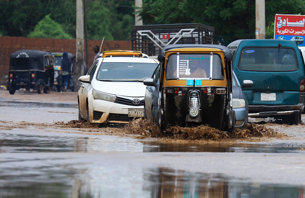 Des véhicules roulent dans une rue inondée à la suite de fortes pluies dans la capitale soudanaise Khartoum, le 13 août 2022. Photo par ASHRAF SHAZLY / AFP via Getty Images.