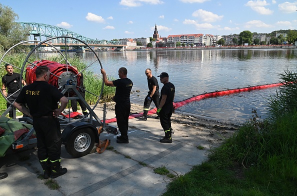 Des pompiers polonais ont installé un barrage flottant pour attraper des poissons morts de la rivière Oder, le 16 août 2022, à Gryfino en Pologne. Photo de MARCIN BIELECKI/AFP via Getty Images.