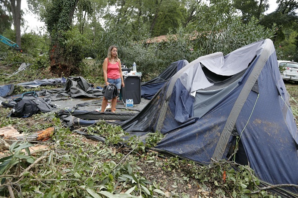 Des campeurs emballent ce qu'il reste de leurs tentes détruites au camping de Sagone en Corse, le 18 août 2022. (Photo : PASCAL POCHARD-CASABIANCA/AFP via Getty Images)