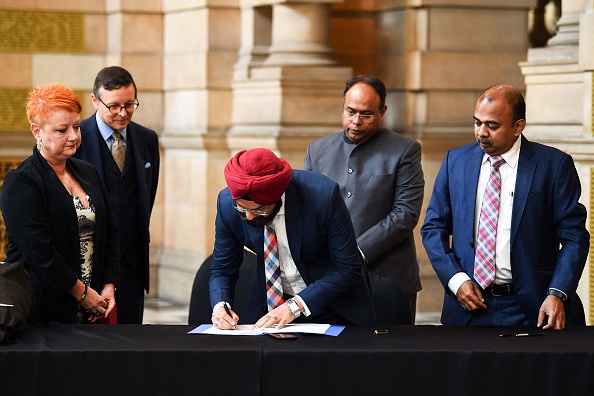 Jaspreet Sukhija, premier secrétaire du haut-commissariat de l'Inde, signe les papiers lors d'une cérémonie de transfert de propriété au Museum de Glasgow le 19 août 2022 alors que l'Écosse se prépare à rapatrier des objets indiens. Photo par Andy Buchanan / AFP via Getty Images.