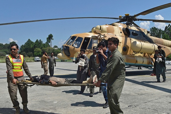 Les soldats de l'armée pakistanaise transportent un touriste secouru de la zone touchée par les inondations à Saidu le 30 août 2022. Photo par Abdul MAJEED / AFP via Getty Images.