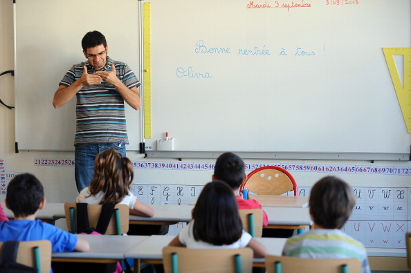 Un enseignant utilise la langue des signes dans une classe spéciale pour enfants sourds, à Ramonville dans le sud-ouest de la France.  (Photo cREMY GABALDA/AFP via Getty Images)
