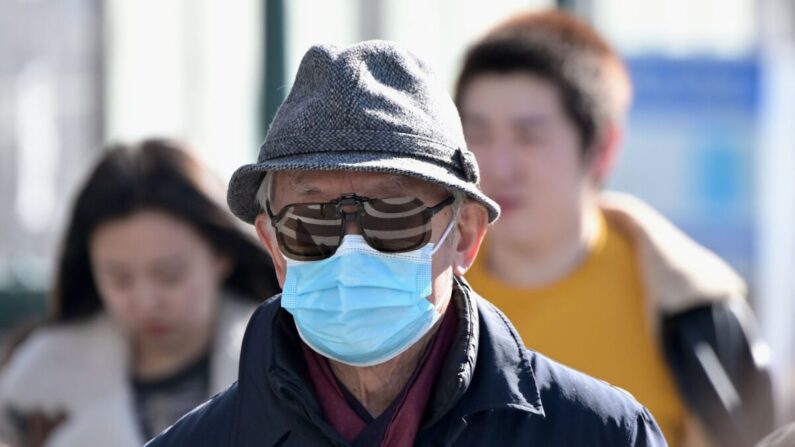 Passant avec un masque chirurgical à Flushing, dans le Queens, à New York, le 3 février 2020. (Johannes Eisele/AFP via Getty Images)