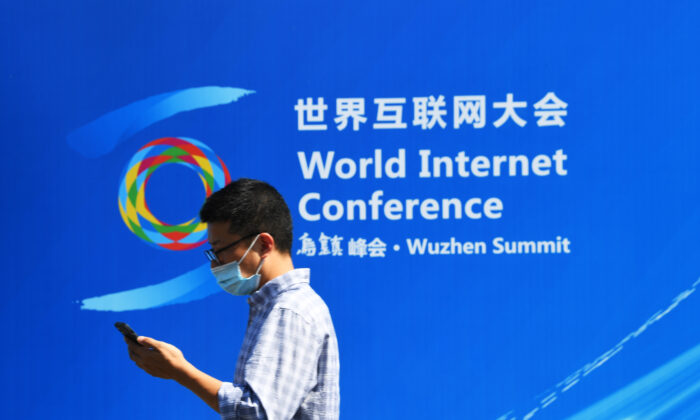 Passant devant une affiche de la Conférence mondiale de l'internet à Wuzhen, dans la province du Zhejiang, le 26 septembre 2021. (Lu Hongjie/Future Publishing via Getty Images)