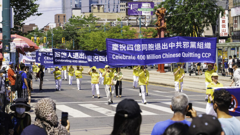 Des personnes regardent le défilé célébrant les 400 millions de Chinois ayant renoncé au Parti communiste chinois et ses organisations affiliées, dans le quartier chinois de Toronto, le 6 août 2022. (Evan Ning/Epoch Times)