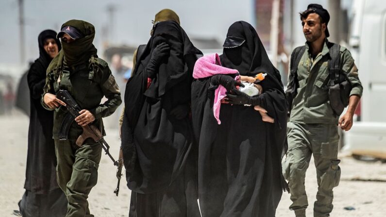 Une patrouille de la sécurité intérieure escorte des femmes, qui seraient des épouses de combattants du groupe État islamique (EI), dans le camp d'al-Hol, dans le gouvernorat d'al-Hasakeh, dans le nord-est de la Syrie, le 23 juillet 2019.(Photo credit should read DELIL SOULEIMAN/AFP via Getty Images)