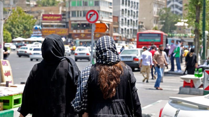 Des femmes portant un foulard marchent dans les rues de Téhéran, près de la place Tajrish, le 12 juillet 2022. (Photo by ATTA KENARE/AFP via Getty Images)