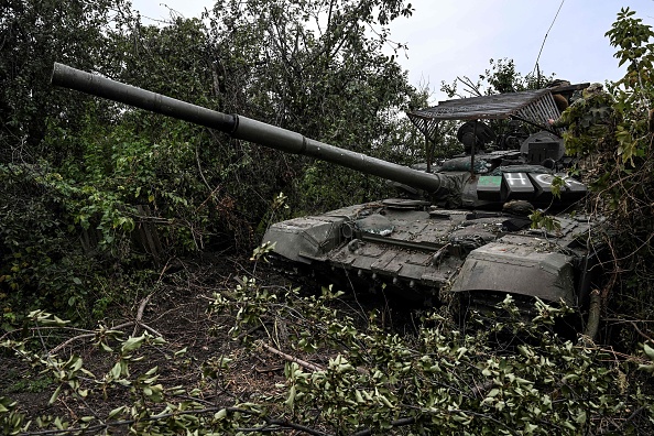 Un char russe abandonné dans la végétation d'un village à la périphérie d'Izyum, dans la région de Kharkiv, les forces ukrainiennes ont déclaré que leur contre-offensive éclair avait repris du terrain au cours des dernières 24 heures le 11 septembre 2022. Photo de Juan BARRETO / AFP/ via Getty Images.