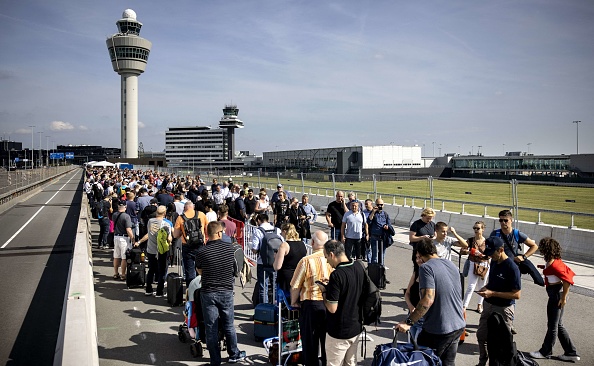 Des voyageurs font la queue à l'aéroport de Schiphol, le 12 septembre 2022, après que l'aéroport de Schiphol a demandé à plusieurs compagnies aériennes d'annuler des vols en raison d'une pénurie de personnel de sécurité. (Photo : RAMON VAN FLYMEN/ANP/AFP via Getty Images)