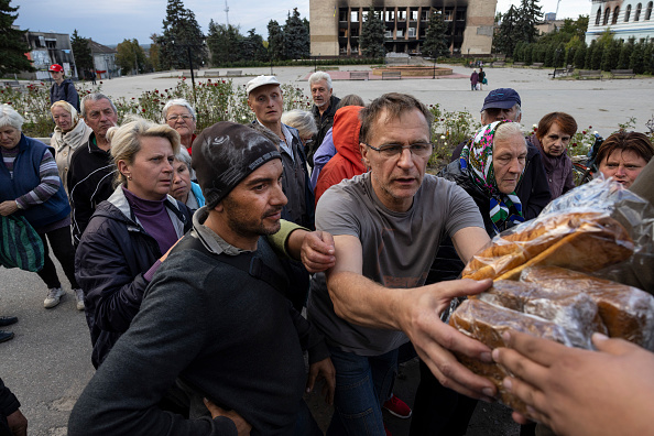 -Les résidents prennent du pain à l’organisation humanitaire locale. Photo de Paula Bronstein/Getty Images.