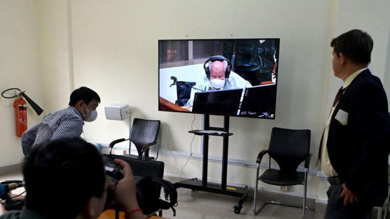 Un journaliste prend une photo de l'ancien dirigeant des Khmers rouges, Khieu Samphan, alors que son image est diffusée sur une vidéo en direct pendant le verdict de son procès devant la Chambre extraordinaire des tribunaux cambodgiens (CETC), à Phnom Penh, le 22 septembre 2022. (Photo by TANG CHHIN SOTHY/AFP via Getty Images)
