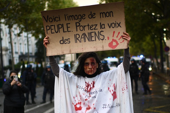 -C'est l'image de mon peuple. Portez la voix des Iraniens alors qu'elle se tient devant la police anti-émeute lors d'une manifestation de soutien aux manifestants iraniens à Paris, le 25 septembre 2022. Photo de Christophe ARCHAMBAULT / AFP via Getty Images.